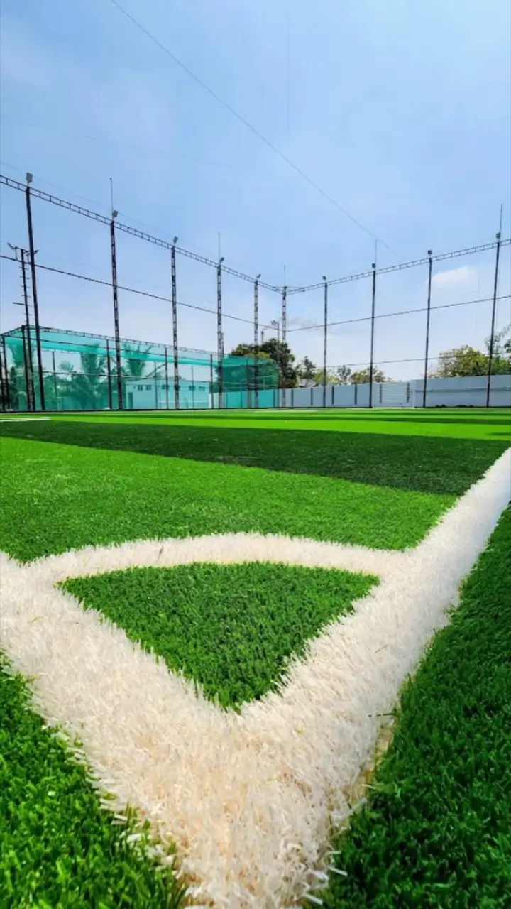 Corner of the football and box cricket turf at Sportiv Bloc, with floodlit nets behind